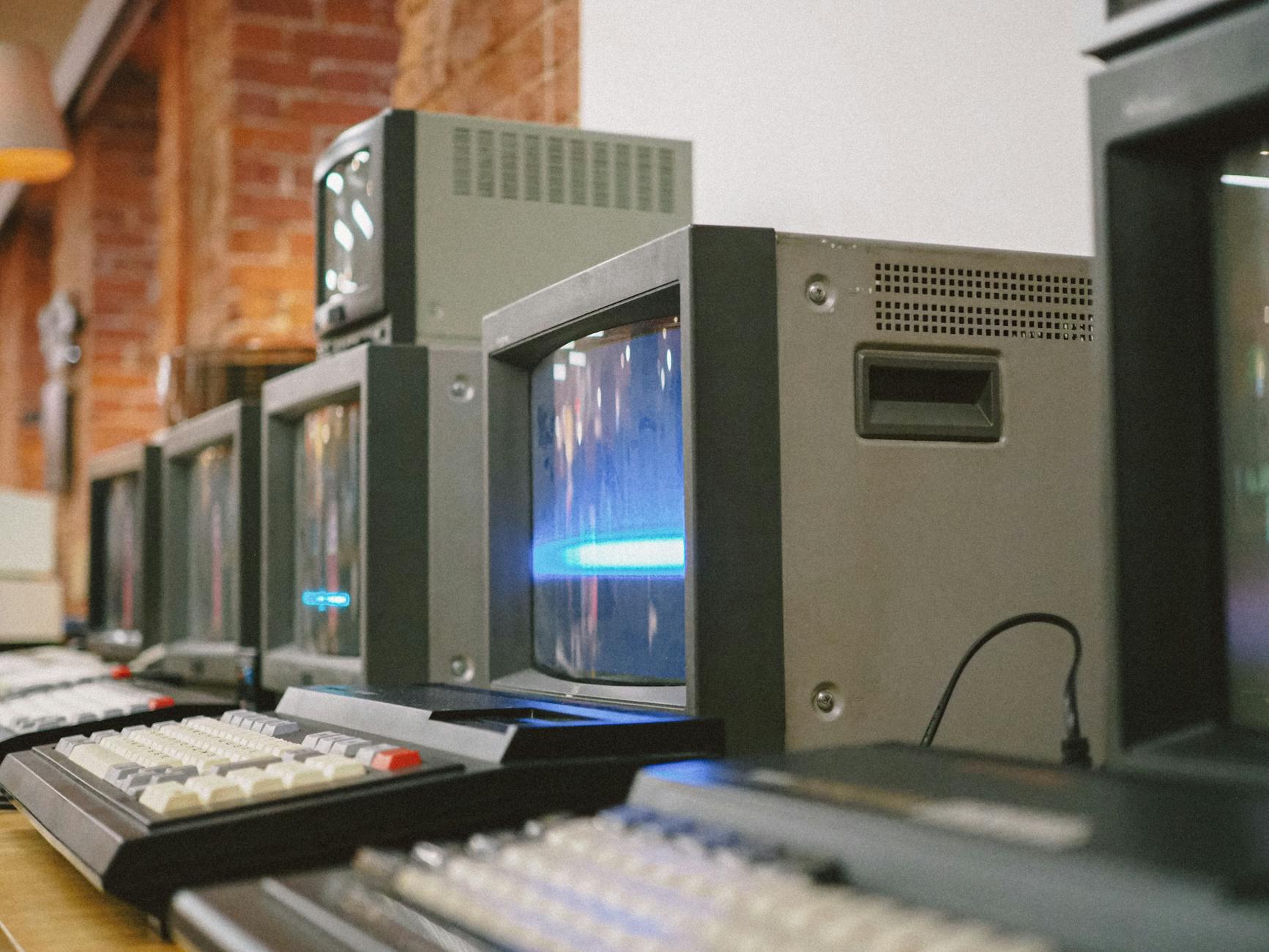 Rząd starych monitorów CRT ustawionych obok siebie w pomieszczeniu