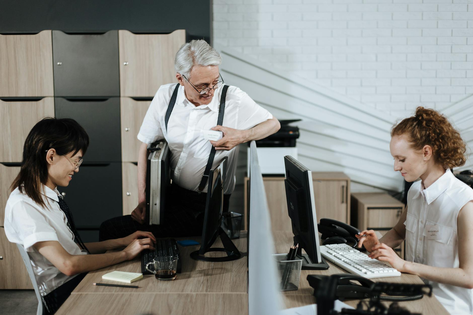 Zespół biurowy przy biurkach omawia zadania w pracy