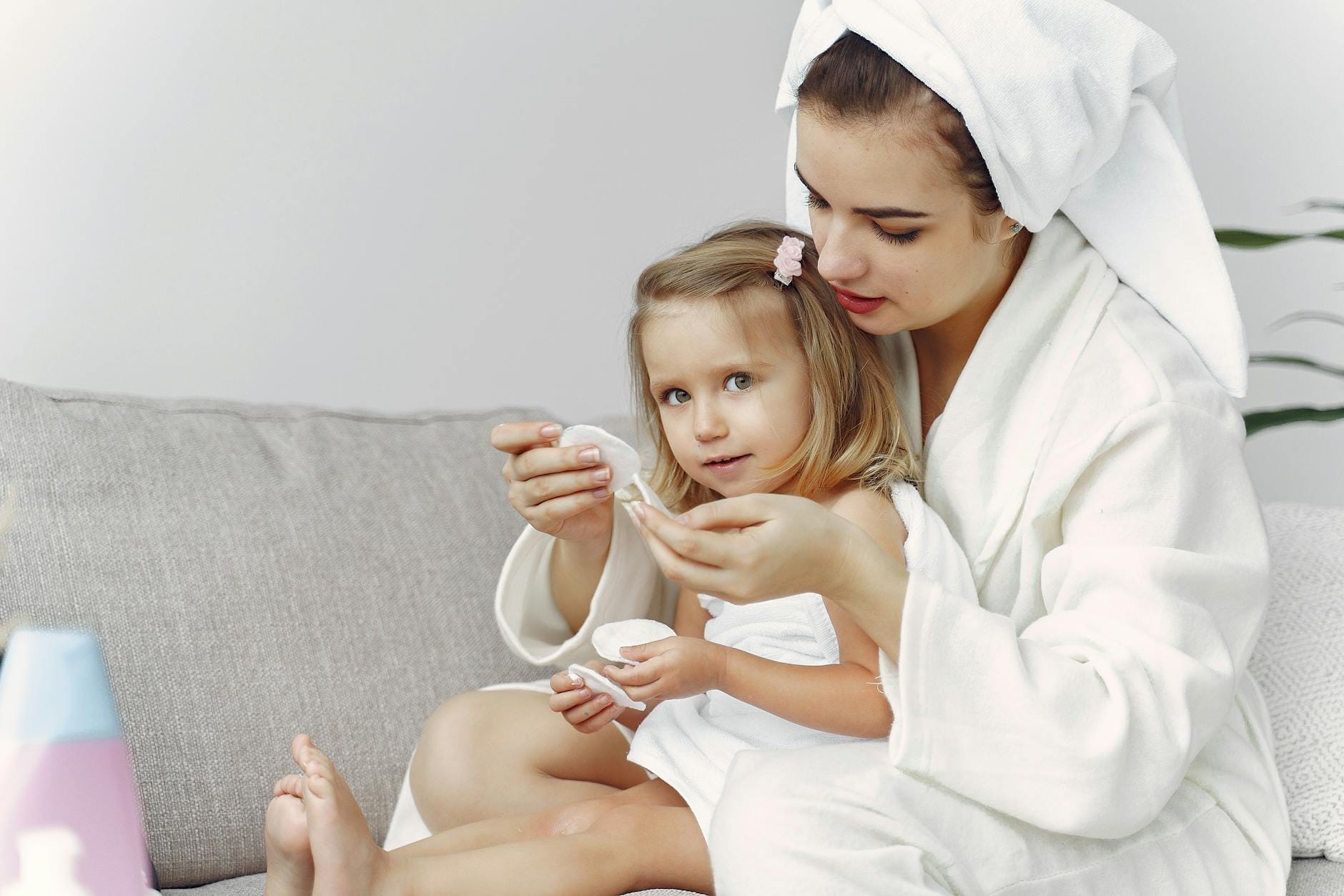 Mama z córką w szlafrokach przytulają się w domowej łazience