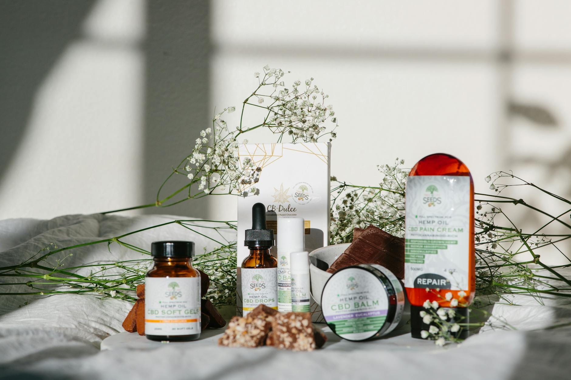 Produkty CBD i konopi z kwiatowymi akcentami w naturalnym świetle