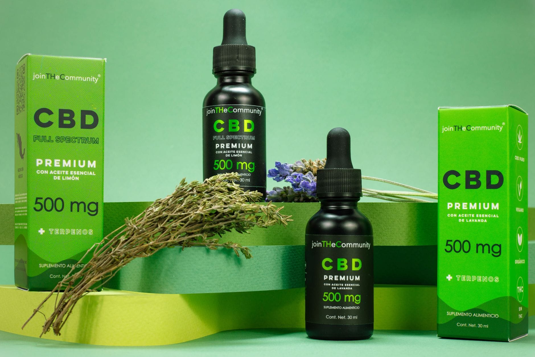 Butelka olejku CBD z pudełkami i lawendą na zielonym tle